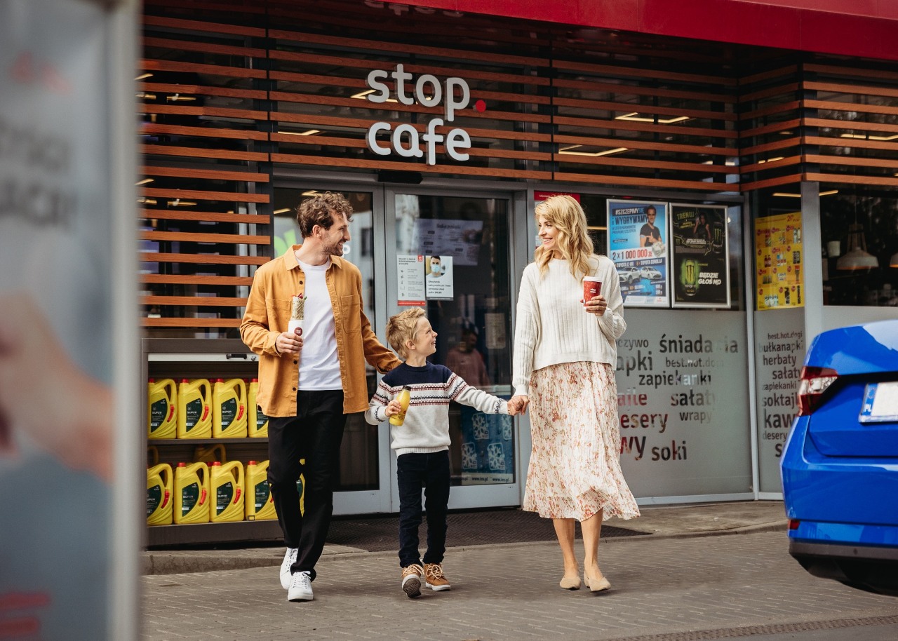 Kobieta, mężczyzna i dziecko wychodzą z kawiarni Stop Cafe.